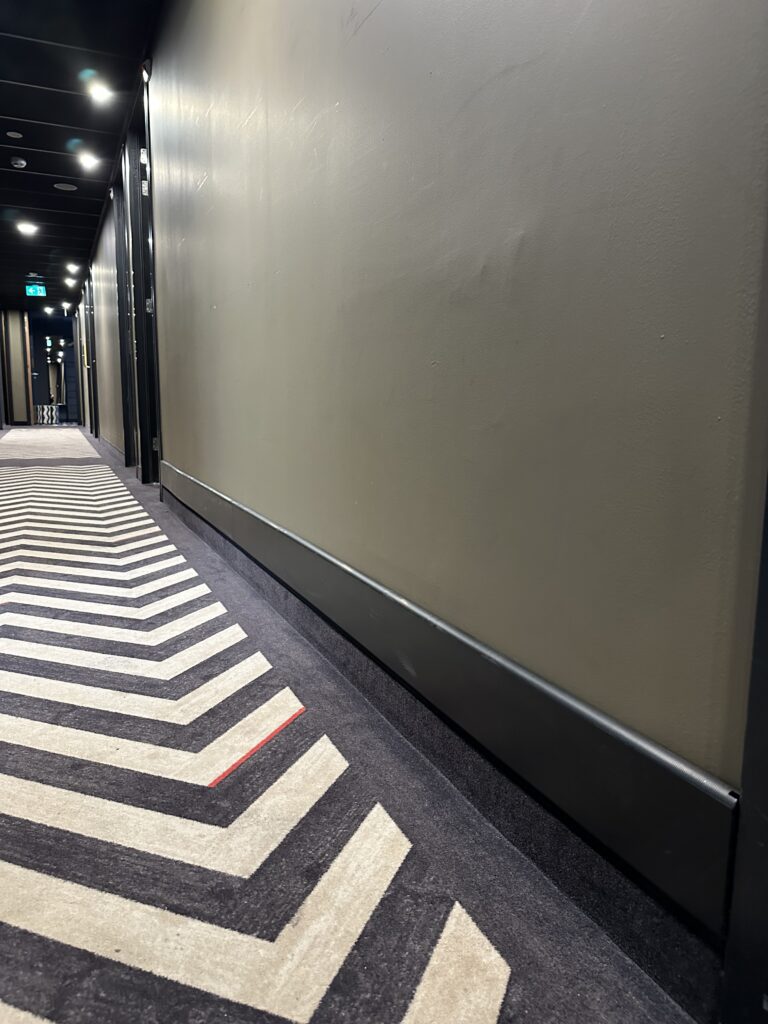 Zwarte stootranden met tapebevestiging in hotelgang